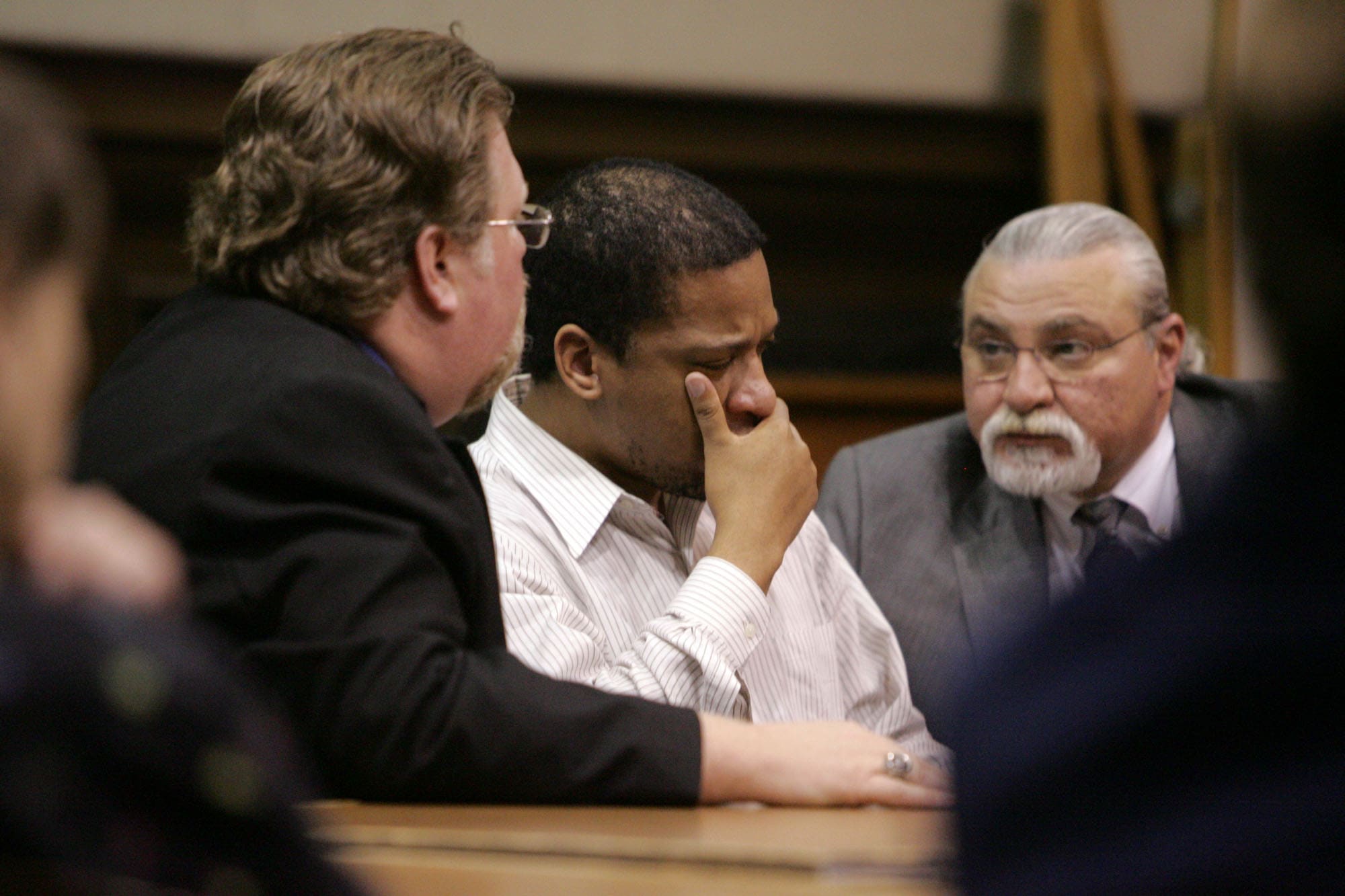 Defendant with attorneys in courtroom
