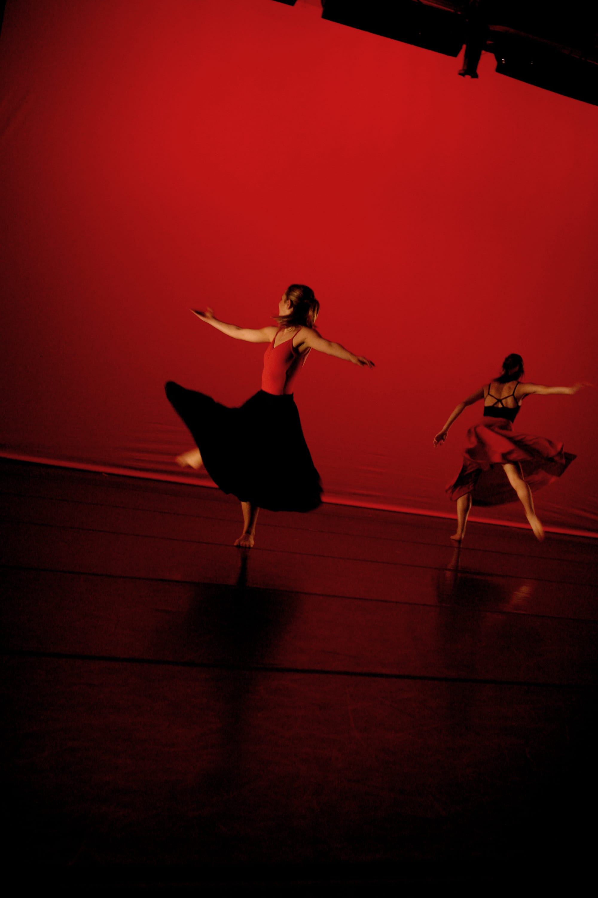 Contemporary dancers performing on stage with red lighting