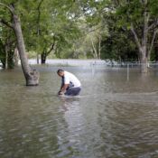 Gabriel Yanes peddles his bike through floodwaters near the intersection of North Main Street and Second Street in the Red Star District of Cape Girardeau, MO, on Thursday, April 28, 2011.