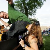 Brandi Miller, of Iowa City, places a band bumper sticker on Roger Lewis, of Cedar Rapids, during the first Uptown Friday Nights event of the season held at Greene Square Park in Cedar Rapids on Friday, May 22, 2009 (Chris Mackler/The Gazette).