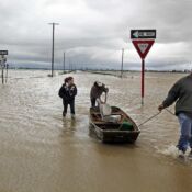 From left, April Gensler, Josh Sherfield and Steve Hyten cross the westbound lanes of US 60 with their boat in-tow in Essex, MO on Wednesday, April 27, 2011. The group unsuccessfully tried to reach Gensler's home to collect some belongings left behind during evacuation the day before. "The current was just too strong for our motor," said Gensler. "If the current wasn't so bad, we would've made it."